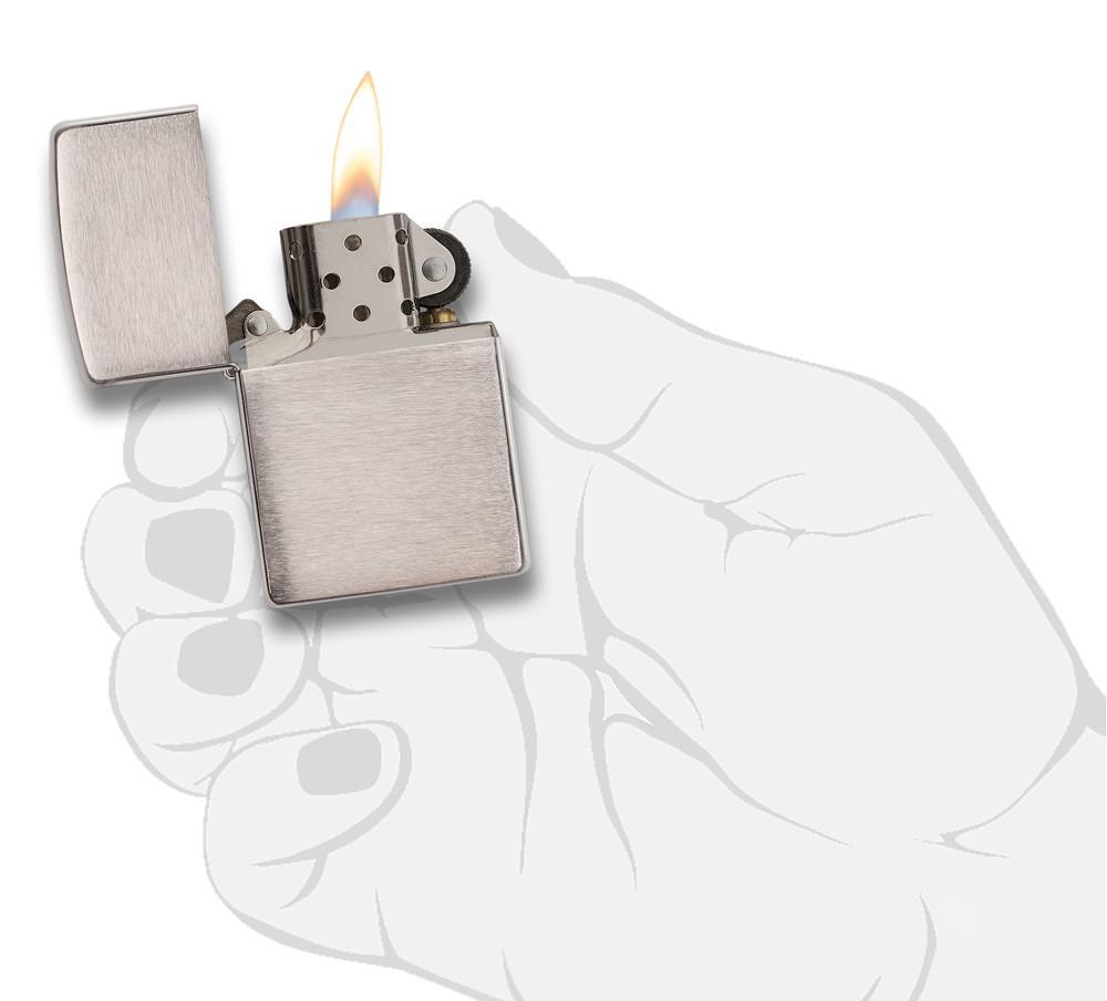 Vue de face briquet Zippo Armor Chrome Brushed, ouvert avec flamme dans une main stylisée