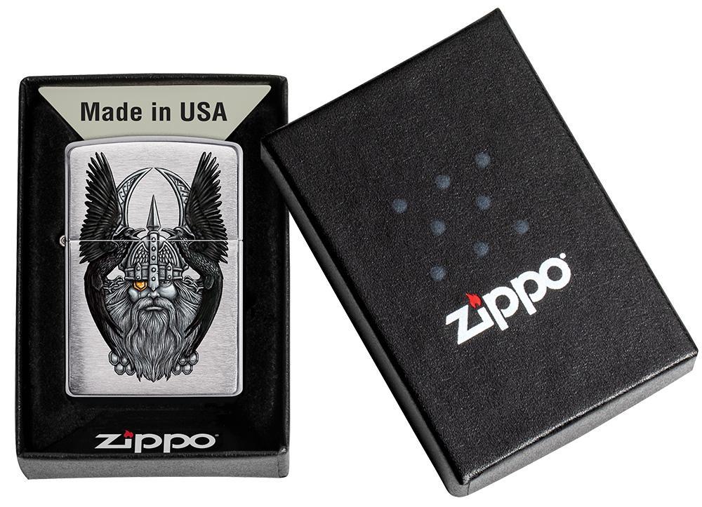 Vue de face 3/4 briquet Zippo chrome brossé avec tête d'Odin, père des dieux dans une boîte cadeau ouverte